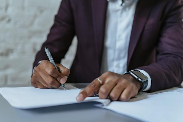 person using a pen to sign a lease agreement